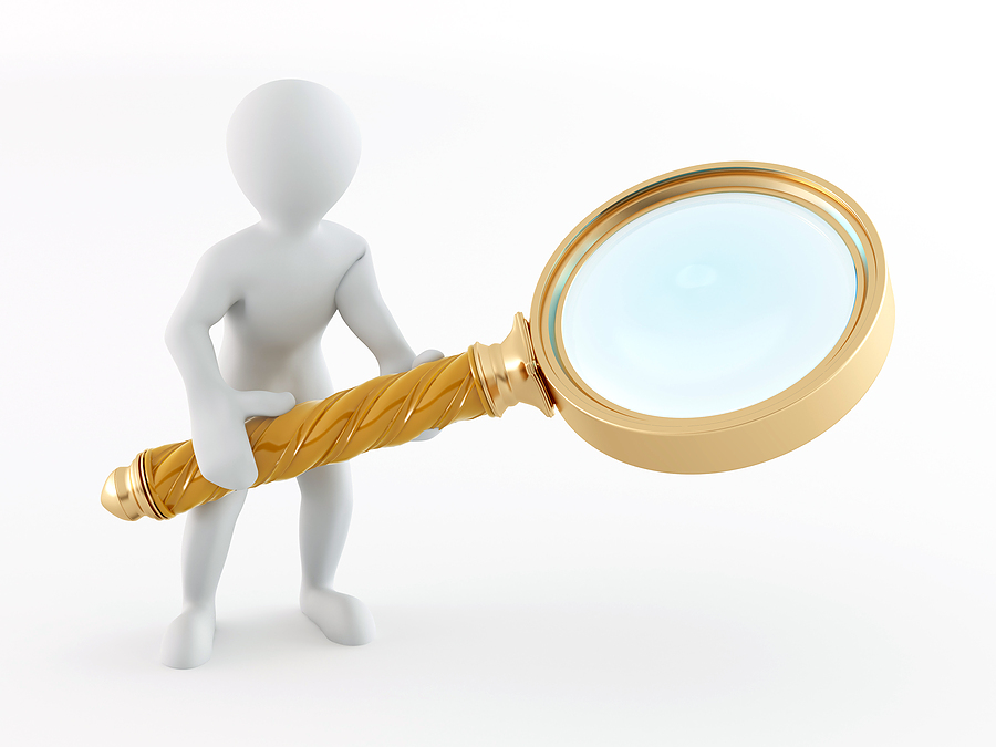Stock image of a man holding a large magnifying glass